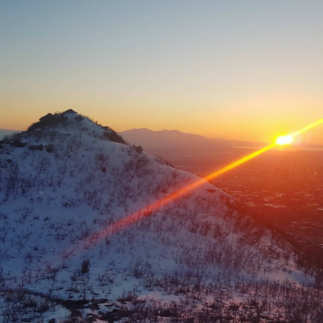 Sunset breaking over a snow-dusted Wasatch ridgeline